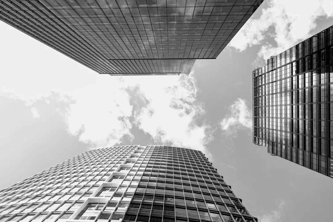 Three modern skyscrapers viewed from below against sky.